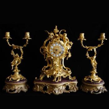 Bronzové hodiny se svícny na dřevěných podstavcích Bronzové hodiny se svícny na dřevěných podstavcích